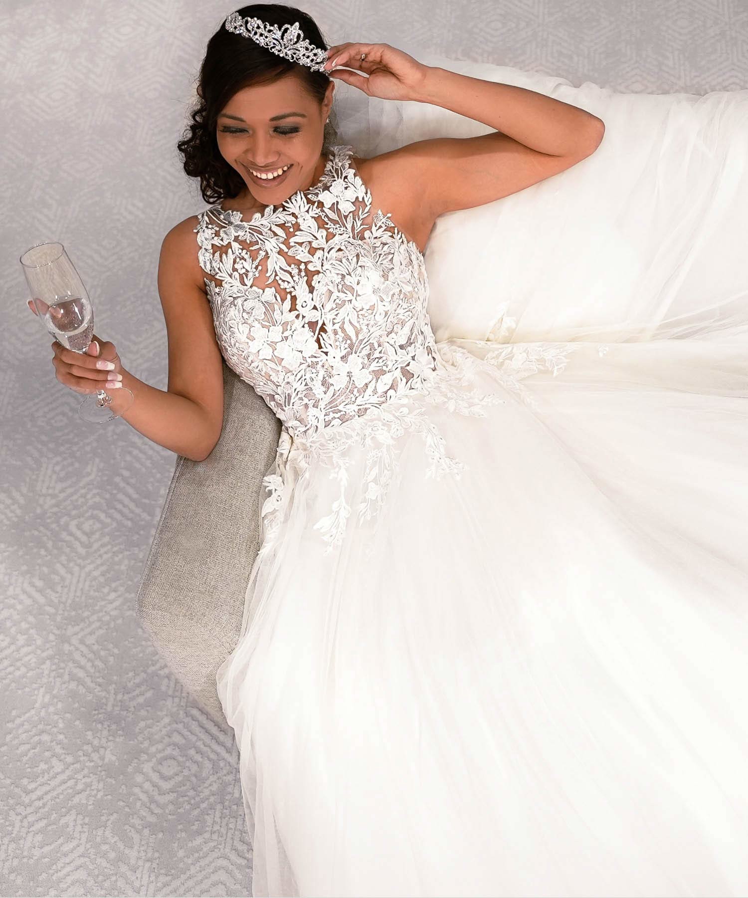 Model wearing a white bridal gown sitting on the sofa - Mobile Desktop