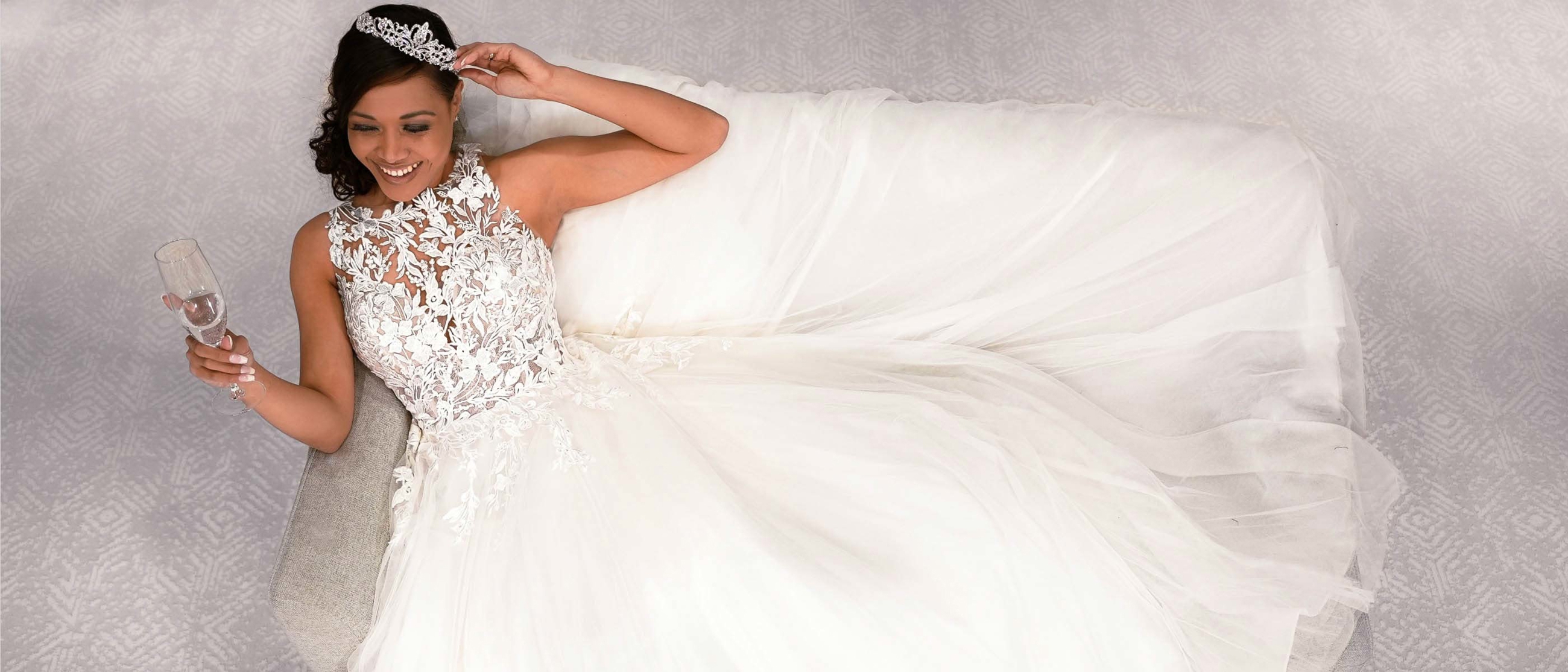 Model wearing a white bridal gown sitting on the sofa